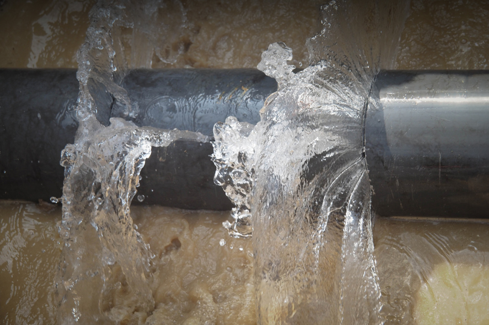 Plumber repairing a damaged plumbing pipe
